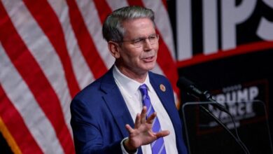 Scott Bessent speaks at a Republican party campaign event in August 2024. He is seen gesturing while standing at a podium, with an American flag in the background.