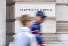 People walk past a HM Revenue & Customs office in London