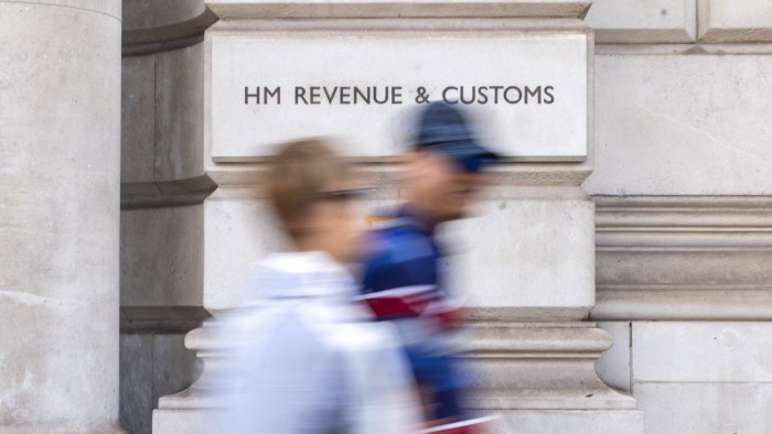 People walk past a HM Revenue & Customs office in London