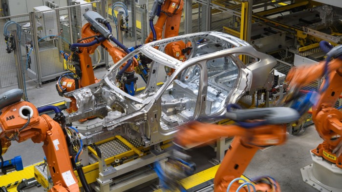 Robotic arms rivet car panels together in the aluminium body shop, part of Jaguar Land Rover’s advanced manufacturing facility in Solihull