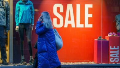 A shopper passes a sale sign in a shop window in Leeds, UK